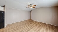 Located at 200 Logan Dr in Phenix City, Alabama, this single-floor, 3-bedroom, 2-bathroom home offers a functional and well-appointed layout throughout. Light wood-look flooring flows continuously across the entire home, creating a cohesive and clean aesthetic in every room.

The open-concept kitchen and living area serves as the heart of the home. The kitchen is equipped with white shaker-style cabinetry, a striking stacked stone tile backsplash, black appliances including a range, over-the-range microwave, and refrigerator, along with ample counter and storage space. A ceiling fan with integrated lighting anchors the adjoining living area, which features a textured ceiling and a window that brings in natural light.

The primary bedroom is a generously sized retreat with a vaulted ceiling, neutral-toned walls, and its own ceiling fan. Additional bedrooms offer comfortable proportions, natural light from windows, and the same wood-look flooring. One bedroom includes a closet with a wire storage rack. The two bathrooms are cleanly designed, each featuring a tub/shower combination with white tile surround, a vanity with storage cabinetry, a mirror, and wood-look flooring. The overall ambiance of the home is bright, neutral, and move-in ready.