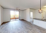Located in the heart of Coral Gables, Florida, this single-floor residence at 353 Aragon Ave offers a clean, modern aesthetic with a thoughtfully designed open-concept layout. Wood-look flooring flows throughout the living spaces, lending warmth and continuity to the interior. The open living and dining area is bright and airy, anchored by a ceiling fan and sliding glass doors that lead to a private balcony with outdoor views. A geometric pendant light serves as a stylish focal point above the kitchen peninsula. The kitchen is well-appointed with white shaker cabinetry, dark granite countertops, a subway tile backsplash, stainless steel appliances including a refrigerator, electric range, and microwave, and a double-basin sink. The bedrooms are generously proportioned, each equipped with a ceiling fan, and one features a walk-in closet with built-in shelving. Natural light filters in through large windows offering pleasant exterior views. The bathrooms include a glass-enclosed shower in one and a full tub-shower combination in the other, both finished in clean white tile. A dedicated in-unit laundry closet with a full-size washer and dryer adds everyday convenience to this well-maintained Coral Gables residence.