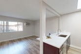 Located at 16553 Vanowen St in Los Angeles, CA, this one-bedroom, one-bathroom unit offers a well-designed single-floor layout with a cohesive, modern aesthetic throughout. The open-concept living and kitchen area forms the heart of the space, where warm wood-style flooring flows continuously underfoot. A bank of windows along the living room wall invites natural light, creating a bright and welcoming atmosphere.

The kitchen is thoughtfully appointed with rich dark cabinetry, crisp white quartz countertops, a stainless steel undermount sink, and a full suite of stainless steel appliances including a gas range, microwave, and refrigerator. A skylight panel overhead enhances the kitchen's brightness. A peninsula with counter seating connects the kitchen seamlessly to the living area, making the layout ideal for everyday living.

The bedroom is a comfortably sized private retreat featuring a window with vertical blinds, a closet, and the same warm flooring found throughout. A wall-mounted A/C unit provides climate control. The bathroom offers a dark-framed vanity mirror, white quartz countertop, dark wood cabinetry, and a full shower-tub combination. Neutral gray tones on the walls lend a clean, move-in-ready feel to every room.