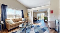 Located at 1101 Pin Oak Ln in Blacklick, Ohio, this single-story home offers a thoughtfully designed open floor plan that connects its main living areas with ease. The living room draws immediate attention with vaulted ceilings that enhance the sense of space, large windows dressed with blinds and drape panels, and hardwood-style flooring that extends throughout much of the home. A cozy secondary sitting area provides a flexible retreat with ample natural light.

The kitchen is well-equipped with dark cabinetry, stainless steel appliances, granite-style countertops, and vaulted ceilings that carry through from the main living space. Pendant lighting and recessed fixtures add a polished touch.

The dining area opens to the outdoors through sliding glass doors, offering views of a lush green landscape — an ideal setting for everyday meals or entertaining.

Bedrooms feature plush carpeting, ceiling fans, and serene neutral tones. The primary bedroom connects to a private en-suite bath with a dark vanity, granite countertop, and walk-in shower. A second bathroom includes safety grab bars and a tub-shower combination with hardwood-style flooring throughout.