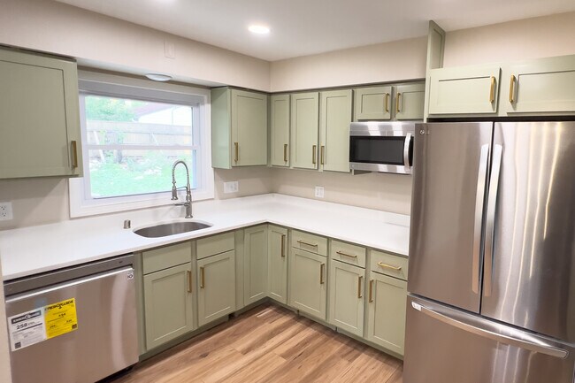 Modern Kitchen with quartz countertops, new stainless appliances, vinyl plank floor, and window look - 811 S 88th St