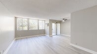 Located at 1020 N Magnolia Ave in Anaheim, California, this 2-bedroom, 2-bathroom residence offers a well-designed single-floor layout finished with light-toned luxury vinyl plank flooring throughout. The open living room serves as the heart of the home, featuring a striking floor-to-ceiling vertical-paneled fireplace, a textured ceiling, and large windows with vertical blinds that invite abundant natural light. A sliding glass door provides additional access to the outdoors. The kitchen is thoughtfully appointed with white shaker cabinetry, stone-toned countertops, a mosaic tile backsplash, stainless steel appliances, and track lighting overhead. The spacious primary bedroom includes a ceiling fan with light, generous wall space, and large windows overlooking greenery, creating a bright and comfortable retreat. The second bedroom also benefits from natural light and a ceiling fan. Both bathrooms are finished consistently with light wood-look flooring, white vanity cabinetry with brushed nickel hardware, stone-toned countertops, mirrored medicine cabinets, and chrome towel bars. One bathroom features a walk-in glass shower, while the other includes a tub-shower combination. A connecting hallway ties all spaces together efficiently, completing this clean and modern Anaheim residence.
