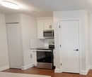 This contemporary 750 square foot apartment in Philadelphia offers a blend of comfort and style. The space is efficiently designed with two bedrooms, including a spacious 210 square foot primary bedroom, one bathroom, and an open-concept kitchen and living area. Throughout the apartment, warm hardwood floors create a cohesive and inviting atmosphere.

The living area is bright and airy, featuring large windows that flood the space with natural light. A sliding glass door leads to a private outdoor area, perfect for enjoying fresh air. The kitchen boasts modern white cabinetry, stainless steel appliances, and a sleek black faucet, creating a clean and functional cooking space.

The bathroom is elegantly appointed with white subway tiles, a modern vanity, and a shower/tub combination. The bedrooms are well-proportioned, with the primary bedroom offering ample space for a king-sized bed and additional furniture.

Storage is abundant, with a walk-in closet featuring adjustable wire shelving. The apartment's neutral color palette and clean lines provide a blank canvas for personal style. Located at 3131 Walnut St in Philadelphia, this apartment combines urban convenience with comfortable living.