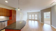Located at 5280 W 115th Pl in Leawood, KS, this well-appointed 2-bedroom, 2-bathroom residence offers a thoughtfully designed single-floor layout. The open-concept kitchen and living area serves as the heart of the home, where light hardwood-style flooring flows seamlessly throughout. The kitchen is outfitted with rich cherry wood cabinetry reaching to the ceiling, dark granite countertops, a tile backsplash, stainless steel appliances including a refrigerator, range, microwave, and dishwasher, and a curved island with pendant lighting—ideal for both cooking and casual dining. The living room extends to a set of French doors that invite natural light and outdoor views. The primary bedroom is a generous retreat featuring plush carpeting, a ceiling fan, and direct access to an en-suite bathroom with dual granite-topped vanities, a glass-enclosed shower, and large-format tile flooring. The second bedroom is carpeted and benefits from a large window with outdoor views. The second bathroom mirrors the same quality finishes, with a granite vanity and tile flooring. A dedicated closet with wire shelving adds practical storage. Track lighting and neutral tones throughout create a cohesive, modern ambiance.
