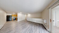 Located at 11 Farnsworth Dr in Slingerlands, NY, this one-bedroom, one-bathroom unit offers a practical and comfortable single-floor layout. The living room is bright and open, featuring durable wood-look vinyl flooring, a baseboard heating system, and a sliding glass door that opens to a private balcony with outdoor views of surrounding greenery, allowing natural light to fill the space. Adjacent to the living area, the kitchen is efficiently designed with warm oak cabinetry, granite-style countertops, a double sink, and black appliances including a refrigerator, electric range, dishwasher, and a range hood. A built-in shelving unit along one wall adds functional storage and display space, complemented by a closet and vinyl plank flooring. The generously sized primary bedroom is carpeted for comfort and features a large sliding closet, vertical blinds on the windows, and a baseboard heater, creating a quiet and cozy retreat. The full bathroom is finished with wood-paneled wainscoting, warm honey-toned wood vanity cabinetry with a white countertop, a bathtub, and wood-look vinyl flooring, giving it a clean and classic look. Throughout the unit, neutral tones create a cohesive and move-in-ready aesthetic.
