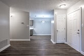 Located at 259 Monmouth Dr in Fayetteville, Georgia, this single-floor home offers a clean, updated interior with a cohesive design aesthetic carried throughout every room. Warm wood-look flooring runs consistently across the living areas, bedrooms, and bathroom, creating a unified and inviting atmosphere.

The living area is open and well-lit, featuring a large sliding glass door that allows natural light to fill the space and provides direct access to the outdoors. A front entry door and textured ceiling complete the room's practical design.

The kitchen is thoughtfully appointed with olive-toned cabinetry on both upper and lower sections, white countertops, a stainless steel sink, and a mosaic tile backsplash that adds visual interest. A black appliance suite, including a range and refrigerator, pairs well with the cabinetry, while a skylight overhead keeps the kitchen bright.

The bedroom features a ceiling fan with integrated lighting, a window for natural ventilation, and access to a walk-in closet, offering generous storage. A secondary room with two white panel doors provides additional flexible space, while a ceiling-mounted light fixture keeps it well-illuminated.

The bathroom includes a full tub-shower combination, a window for natural light, and a vanity with matching olive-toned cabinetry, a light countertop, and a wide mirror — consistent with the finishes found throughout the home.