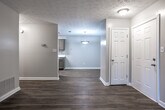 Located at 259 Monmouth Dr in Fayetteville, Georgia, this single-floor home offers a clean, updated interior with a cohesive design aesthetic carried throughout every room. Warm wood-look flooring runs consistently across the living areas, bedrooms, and bathroom, creating a unified and inviting atmosphere.

The living area is open and well-lit, featuring a large sliding glass door that allows natural light to fill the space and provides direct access to the outdoors. A front entry door and textured ceiling complete the room's practical design.

The kitchen is thoughtfully appointed with olive-toned cabinetry on both upper and lower sections, white countertops, a stainless steel sink, and a mosaic tile backsplash that adds visual interest. A black appliance suite, including a range and refrigerator, pairs well with the cabinetry, while a skylight overhead keeps the kitchen bright.

The bedroom features a ceiling fan with integrated lighting, a window for natural ventilation, and access to a walk-in closet, offering generous storage. A secondary room with two white panel doors provides additional flexible space, while a ceiling-mounted light fixture keeps it well-illuminated.

The bathroom includes a full tub-shower combination, a window for natural light, and a vanity with matching olive-toned cabinetry, a light countertop, and a wide mirror — consistent with the finishes found throughout the home.