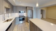 Located at 4200 NW 107 Ave in Doral, Florida, this modern unit offers a well-designed, single-floor open-concept layout finished with light wood-tone flooring throughout. The living and dining area flows seamlessly into a contemporary kitchen, which serves as the centerpiece of the space. The kitchen is outfitted with wood-grain cabinetry extending to the ceiling, a geometric-patterned tile backsplash, white quartz countertops, a central island, and a full suite of stainless steel appliances including a French door refrigerator, electric range, built-in microwave, and dishwasher. Pendant lighting above the island adds a polished touch. The bedrooms are generously sized with large windows that invite natural light and frame views of the surrounding palm-lined landscape. Closets feature built-in shelving for organized storage. The unit includes two full bathrooms: one with a soaking tub and subway tile surround, and another with a glass-enclosed walk-in shower, also finished in subway tile. Both bathrooms feature wood-grain vanities with white quartz countertops. Clean white walls, consistent flooring, and a neutral palette give the entire space a bright, cohesive, and modern aesthetic.