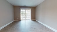 This single-floor residence offers a thoughtfully designed layout with a blend of comfort and modern finishes throughout. The open-concept kitchen is a standout feature, equipped with stainless steel appliances including a French door refrigerator, microwave, and range, all complemented by rich dark cabinetry, granite countertops, and a tile backsplash. A kitchen island provides additional prep and storage space, flowing seamlessly into the dining and living areas finished with light hardwood-style flooring.

The living area is bright and welcoming, featuring a sliding glass door with vertical blinds that opens to an outdoor space, allowing natural light to fill the room. Bedrooms are carpeted for comfort and include generous closet space with wire shelving systems, including a spacious walk-in closet. Windows with horizontal blinds provide natural light in each bedroom.

The bathrooms are finished with dark wood vanities, granite countertops, and light wood-style tile flooring, creating a cohesive and polished aesthetic. A dedicated in-unit laundry area houses a full-size washer and dryer, adding everyday convenience. Neutral warm-toned walls throughout the space create a calm, inviting ambiance well-suited for comfortable living.