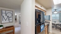 Located at 3006 Hickory Woods Dr in Roanoke, Virginia, this single-floor residence offers a thoughtfully designed layout with two bedrooms and two full bathrooms. The galley-style kitchen is efficiently organized with warm wood cabinetry, dark countertops, tile flooring, and black appliances including a refrigerator, range, microwave, and dishwasher — all complemented by a skylight that brightens the space. The kitchen flows toward a combined dining and living area, where the dining room features a ceiling fan, carpeted flooring, and a window with natural light. The living room continues the carpet flooring with neutral-toned walls, providing a relaxed and welcoming atmosphere. The primary bedroom is a comfortable retreat with carpet, natural light from a window with blinds, and a closet. The second bedroom mirrors a similar design with neutral gray walls, carpet, and a window. Both bathrooms are well-appointed; one includes a tub-shower combination, tile flooring, and a wood-toned vanity. A dedicated laundry room with full-size washer and dryer, louvered bi-fold doors, shelving, and tile flooring adds everyday convenience. The overall design is clean, functional, and well-suited for comfortable residential living.