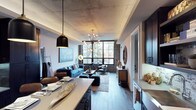 This Dallas loft showcases a compelling blend of industrial and modern design across a single, open-concept floor. Exposed concrete ceilings and original brick walls establish the space's raw, urban character, while warm hardwood flooring and curated furnishings soften the aesthetic for an inviting ambiance. The living area is anchored by a tufted blue sofa and complementary seating, bathed in natural light streaming through large, steel-framed windows that frame views of surrounding greenery. A sputnik-style chandelier adds a retro-contemporary focal point overhead. The kitchen flows seamlessly from the living space, featuring dark cabinetry, a generous countertop island with pendant lighting, and modern fixtures — ideal for both everyday living and entertaining. Rich layering of textures throughout — from woven rugs and decorative accents to warm wood tones — creates a cohesive and thoughtfully designed interior. The single-level layout ensures a fluid connection between all areas of the space, making it feel both spacious and functionally unified. This property exemplifies the hallmark loft-living experience found in urban Dallas.