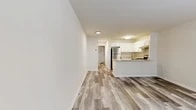 Located at 32 Nob Hill Dr in Elmsford, NY, this efficiently designed 2-bedroom, 1-bathroom residence offers a well-organized single-floor layout. The open-concept living and dining area is bright and welcoming, featuring wood-style plank flooring in cool gray tones and a neutral color palette that lends a clean, modern aesthetic throughout.

The kitchen is a standout feature, equipped with crisp white shaker cabinetry, light granite countertops, a peninsula for additional prep and seating space, and a full suite of stainless steel appliances including a gas range, dishwasher, and refrigerator. Wood-style flooring continues seamlessly from the living area into the kitchen.

Both bedrooms are comfortably sized and finished with plush carpet flooring and neutral walls, creating a calm and restful atmosphere. The primary bedroom benefits from a window with outdoor views, filling the room with natural light. Additional closets throughout the unit provide ample storage.

The bathroom is finished with wood-style flooring, a granite-topped vanity, and a tub/shower combination. Practical amenities include an in-unit laundry area and multiple utility and storage spaces. The home's consistent modern finishes and functional layout make it a well-appointed residence in Westchester County.