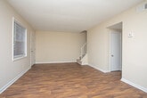 Located at 600 Redmond Rd NW in Rome, Georgia, this two-story home offers a well-organized layout spread across two floors. The main level features rich, dark hardwood-style flooring that flows through the entry area and living spaces, creating a warm and cohesive feel. A carpeted staircase with a white railing connects the floors, adding a clean, classic touch to the interior. The kitchen is a standout feature, outfitted with dark espresso cabinetry, brushed nickel hardware, stone-look countertops, and a striking mosaic tile backsplash in earthy tones of brown and cream. A black range with overhead ventilation completes the functional cooking space. The living and common areas are bright and open, with neutral beige walls, white trim, and textured ceilings that enhance the spacious feel. Multiple windows fitted with horizontal blinds allow natural light to fill the rooms. Upstairs, the bedrooms offer plush carpeting underfoot, ceiling fans with integrated lighting, and generous closet space. Each room maintains the consistent neutral palette, providing a clean and move-in-ready atmosphere. Overall, this home presents a practical and comfortable layout with thoughtful finishes throughout both floors.