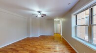 Located at 1116 Washington Blvd in the desirable Oak Park, Illinois neighborhood, this single-floor unit offers a well-designed layout with a cohesive, comfortable feel throughout. Warm hardwood flooring extends across the living areas and bedrooms, lending a timeless character to the space. Ceiling fans are present in multiple rooms, enhancing air circulation and comfort year-round.

The living area is generously proportioned, offering an open and airy atmosphere with neutral-toned walls that complement the natural warmth of the floors. The kitchen is well-appointed with dark espresso cabinetry, granite countertops, a stainless steel sink, and matching appliances including a gas range and over-the-range microwave, all set atop the same rich hardwood flooring.

The bedrooms are comfortable and well-lit, with one room featuring a window that frames views of the lush, tree-lined neighborhood outside. Built-in closet space and access to a utility panel are also present. Cast iron radiators are a recurring architectural detail throughout the unit, nodding to the building's classic character while providing efficient heating.

The bathroom is cleanly finished with tile flooring, a tiled tub-shower surround with decorative accent banding, a dark-stained vanity with an undermount sink, and a frosted privacy window for natural light.