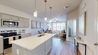 Located at 201 Munn Road in Nashville, TN, this one-bedroom, one-bathroom residence offers a thoughtfully designed single-floor layout that maximizes every square foot. The open-concept kitchen and living area forms the heart of the home, where a central island with a white quartz countertop and undermount sink anchors the space. Gray shaker-style cabinetry lines the kitchen walls, complemented by a subway tile backsplash and a full suite of stainless steel appliances, including a refrigerator, range, microwave, and dishwasher. Pendant lights above the island add a polished finishing touch. Light wood-style flooring flows seamlessly from the kitchen into the living area, where large windows invite an abundance of natural light and views of the surrounding neighborhood. A ceiling fan enhances comfort in the living space. The bedroom offers a cozy retreat with plush carpeting, dual windows with outdoor views, and a ceiling fan. Two closets provide generous storage. The full bathroom features gray cabinetry, a white quartz vanity, and a combined tub and shower. A dedicated laundry area and utility room round out the functional layout of this clean, modern Nashville residence.