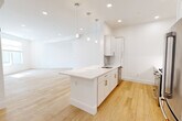 Located at 95 Fawcett St in Cambridge, MA, this thoughtfully designed 3-bedroom, 2-bathroom single-floor residence offers a clean, modern aesthetic throughout. Light hardwood flooring flows seamlessly across all rooms, complementing the crisp white walls and recessed lighting that create a bright, airy atmosphere.

The open-concept kitchen is a standout feature, boasting a central island with a white quartz countertop and undermount sink, white shaker cabinetry, a subway tile backsplash, and stainless steel appliances including a gas range, built-in microwave, and dishwasher. Pendant lighting above the island adds a stylish touch, while the layout opens directly into the spacious living area.

The generously sized primary bedroom offers ample room and is complemented by two additional well-proportioned bedrooms, each featuring natural light from large windows with blinds and recessed lighting. The two bathrooms are finished with clean, modern appointments — one features a walk-in glass-enclosed shower with marble-style tile surround, a white vanity with quartz countertop, and light tile flooring. The second bathroom mirrors this refined simplicity. A dedicated closet and practical layout round out this well-organized, move-in-ready Cambridge home.