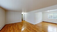 Located at 272 Ward Ave in Bordentown, NJ, this 2-bedroom, 1-bathroom residence offers a well-organized single-floor layout with a clean, neutral aesthetic throughout. Warm-toned hardwood floors extend across the living room and both bedrooms, lending a cohesive and inviting character to the space. The living room is generously sized, bathed in natural light through large windows, and features baseboard heating and a wall-mounted AC unit for year-round comfort. The primary bedroom is a comfortable, well-proportioned room with its own window and closet, while the second bedroom similarly benefits from natural light and hardwood flooring. A connecting hallway ties the rooms together seamlessly. The kitchen is efficiently designed with rich medium-toned wood cabinetry, dark countertops, and black appliances including a gas range, microwave, and refrigerator, all set atop tile flooring. The bathroom is bright and clean, featuring tile flooring, a window for natural ventilation, and a bathtub. Built-in shelving in the hallway adds practical storage. The overall ambiance is simple, clean, and functional, making this Bordentown residence a practical and comfortable home.