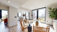 Located in the heart of Midtown Atlanta, this sleek, light-filled residence offers a thoughtfully designed open-concept layout across a single floor. The living and dining area is anchored by dramatic floor-to-ceiling windows that frame sweeping views of the Atlanta skyline and lush treetops below, flooding the space with natural light and creating an airy, elevated ambiance. Wide-plank hardwood-style flooring flows seamlessly throughout, complementing the clean, contemporary aesthetic.

The kitchen is a standout feature, offering a galley-style configuration with warm wood cabinetry, light quartz countertops, stainless steel appliances including a professional-grade gas range, and a deep undermount sink — all oriented toward the living area to maintain the open, connected feel.

The bedroom is generously proportioned, featuring its own floor-to-ceiling window with expansive views, a ceiling fan, and a calm, neutral palette. Three well-appointed bathrooms serve the residence, including one with a glass-enclosed walk-in shower with built-in shelving and wood-toned vanity, and another featuring a full soaking tub with large-format tile surround.

A dedicated closet and a bright hallway entry complete this refined urban residence, designed for modern living in one of Atlanta's most vibrant neighborhoods.