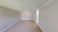 Located at 1201 Spruce Ct in Kent, Ohio, this two-bedroom, one-bathroom unit offers a practical and well-organized single-floor layout. The space is designed for efficient living, with each room serving a clear purpose within a compact footprint.

The generously sized primary bedroom features soft wall-to-wall carpeting, crown molding, a textured ceiling, and a large double-door closet for ample storage. The second bedroom is equally comfortable, with plush carpeting, crown molding, a textured ceiling, and a window fitted with vertical blinds that allows natural light to filter in. Both bedrooms are finished in a neutral gray palette, creating a calm and versatile atmosphere.

The living area includes a front entry door flanked by a wide window that brings in natural light and provides views of the exterior greenery. Carpeting and a textured ceiling continue the consistent finish throughout.

The kitchen is equipped with warm wood cabinetry, light countertops, a stainless steel single-basin sink, and a white electric range and refrigerator — offering all essential appliances in a straightforward galley-style arrangement.

The bathroom features tile flooring, a wood vanity with a granite-style countertop, and a full tub and shower combination with a curtain rod, providing practical functionality. A hallway connects the rooms, completing this efficient and move-in-ready layout.