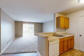 Located at 21901 Stratford Place Boulevard in Browntown, MI, this single-floor, three-bedroom, two-bathroom home offers a practical and comfortable layout designed for everyday living. The open-concept kitchen and living area form the heart of the home, where warm oak cabinetry, a peninsula with a built-in sink, and a dishwasher define the kitchen space. The adjacent living room features neutral-toned carpet, warm beige walls, and a sliding glass door with vertical blinds that opens to a private balcony, filling the room with natural light and providing outdoor access. A separate dining room completes the main living area. Each of the three carpeted bedrooms offers a calm, neutral aesthetic with natural window light and closet access — the spacious primary bedroom includes a notably generous footprint. With five closets total throughout the home, storage is plentiful. Both bathrooms feature white tile tub-shower combinations. A dedicated laundry area with in-unit washer and overhead shelving adds everyday convenience. Hardwood-style flooring accents the entry and kitchen areas, while carpet runs throughout the bedrooms and living spaces, creating a cohesive and welcoming interior.