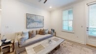 Located at 77 Exuma Way in Santa Rosa Beach, FL, this thoughtfully designed single-floor home offers two bedrooms, two bathrooms, and a comfortable, efficient layout. The open-concept kitchen and living area serves as the heart of the home, featuring dark wood-grain cabinetry, crisp white quartz countertops, a stainless steel appliance suite, and a central island with pendant lighting that doubles as a breakfast bar. Light wood-look tile flooring and crown molding flow throughout, lending a cohesive, coastal-modern aesthetic. The living area is bright and airy, complemented by neutral tones and tasteful décor. Both bedrooms are well-sized and filled with natural light from large windows, each equipped with ceiling fans and ample closet space — four closets total are distributed throughout the home. The primary bedroom connects to a sleek en-suite bathroom showcasing a frameless glass walk-in shower, large-format tile, a dark-cabinetry vanity, and white quartz countertops. A dedicated laundry area with a full-size washer adds everyday convenience. The home also includes a private patio, completing this clean, modern retreat in the heart of Florida's Emerald Coast.