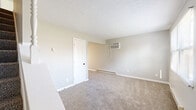 Located at 109-194 Caroline Ct in Circleville, Ohio, this two-story home offers three bedrooms and one bathroom across two well-proportioned floors. The main level features a kitchen equipped with light wood cabinetry, dark countertops, wood-look vinyl flooring, a stainless refrigerator, an electric range, a dishwasher, and a double sink. Natural light flows in through multiple windows, and French doors provide a bright connection to the outdoors. The living room completes the main level's living space. Upstairs, three carpeted bedrooms offer comfortable retreats, each featuring wall-mounted air conditioning units and baseboard heating for year-round climate control. The primary bedroom includes a closet with a sliding door and built-in shelving. The full bathroom is finished with wood-look tile flooring, a white vanity with storage, and a tub-shower combination. Additional features include a utility room, a hallway, and three closets throughout. Textured ceilings and neutral gray and beige tones create a clean, consistent aesthetic throughout the home. The staircase connects the two floors efficiently, making the layout practical and functional for everyday living.
