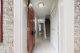 Located at 430 College Pkwy in Rockville, MD, this three-bedroom, three-bathroom home spans three thoughtfully arranged floors. The welcoming entryway features light tile flooring, a bold red front door with brass hardware, a louvered closet, and carpeted stairs leading to the upper level. The main living area is bright and open, with neutral carpet and a large sliding glass door that frames serene backyard views with lush greenery. The kitchen is equipped with dark espresso cabinetry, light granite countertops, a subway tile backsplash, and black stainless appliances including a gas range, dishwasher, and refrigerator. Three well-proportioned bedrooms offer soft carpeting and louvered closet doors, including a generously sized primary bedroom. The three bathrooms include options with a tub-shower combo finished in white tile and a separate walk-in shower with a glass sliding door. The lower level includes a spacious unfinished basement with tile floors, painted concrete block walls, exposed wood beam ceilings, and a utility room — offering excellent storage or conversion potential. Outside, mature trees and manicured greenery create an inviting curb presence along this established Rockville corridor.