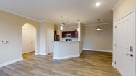 Located at 5150 Jack Byrnes Dr in Murfreesboro, Tennessee, this single-floor residence offers a thoughtfully designed open-concept layout that seamlessly connects the main living areas. The space is unified by rich hardwood-style flooring throughout the common areas, complemented by crown molding and warm neutral tones on the walls.

The kitchen is a standout feature, showcasing rich dark-wood cabinetry, granite countertops, and a full suite of stainless steel appliances including a refrigerator, range, and built-in microwave. A peninsula with pendant lighting serves as both a functional workspace and a natural divider between the kitchen and the open living area, which is further illuminated by recessed and track lighting.

An elegant arched doorway adds architectural character, leading into additional areas of the home. The living and entry areas benefit from multiple windows fitted with blinds, allowing for ample natural light. The bedrooms feature plush carpeting, ceiling fans, and windows that bring in soft, diffused light, creating a comfortable and restful atmosphere. Additional storage is provided through generously sized closets with double doors. The overall design balances practical functionality with clean, classic finishes throughout.