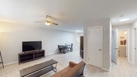 Located at 704 Hampstead Pl in Raleigh, NC, this single-story home offers a clean, modern aesthetic with light wood-style flooring and a neutral gray-and-white color palette carried consistently throughout. The open living and dining area forms the heart of the home, where a ceiling fan with integrated lighting keeps the space comfortable. Natural light filters in through multiple windows fitted with slatted blinds, creating a bright and welcoming atmosphere. The living area flows seamlessly into a dedicated dining space, making the layout practical for everyday living and entertaining. The kitchen is well-appointed with crisp white shaker-style cabinetry, granite countertops, a classic subway tile backsplash, and a full suite of stainless steel appliances including a refrigerator, range, over-the-range microwave, and dishwasher. A skylight adds additional natural brightness to the kitchen. The home features multiple bedrooms, each equipped with a ceiling fan, windows with natural light, and light wood-style flooring. One bedroom includes a closet with built-in shelving. The bathroom is efficiently designed with a vanity, toilet, shower, and a window for natural ventilation. Throughout the home, the consistent finishes and thoughtful layout create a cohesive, comfortable living environment.