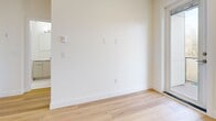 Located at 11779 Burnett St in Maple Ridge, BC, this thoughtfully designed 2-bedroom, 1-bathroom unit offers a bright and efficient layout across a single floor. Light-toned hardwood flooring flows seamlessly throughout, complementing the clean white walls and creating a fresh, modern aesthetic.

The open-concept living, dining, and kitchen area forms the heart of the unit. The kitchen is well-equipped with stainless steel appliances including a refrigerator, electric range, and dishwasher, paired with two-tone cabinetry — warm wood lower cabinets and cream upper cabinets — white quartz countertops, a glossy tile backsplash, and under-cabinet lighting for added functionality.

Both bedrooms are bright and inviting, benefiting from large windows that frame tree-lined outdoor views and allow generous natural light to fill the rooms. Baseboard heaters are present throughout for efficient climate control. The unit includes three closets, providing ample storage. The bathroom features a clean, all-white soaking tub and surround.

A private balcony extends the living space outdoors, offering views of the surrounding neighbourhood. The unit's contemporary finishes, practical layout, and natural light make it a well-rounded and comfortable residence in the Maple Ridge community.