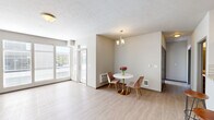 Located at 11813 E Broadway Ave in Spokane Valley, WA, this 2-bedroom, 1-bathroom unit offers a practical and well-appointed single-floor layout. The open-concept living, dining, and kitchen area serves as the heart of the home, featuring light wood-style flooring that flows throughout the main living spaces. Large sliding glass doors flood the living room with natural light and provide direct access to a private patio, offering pleasant outdoor views. A dedicated dining nook is accented by a charming chandelier, adding a touch of elegance to the space.

The kitchen is equipped with rich dark wood cabinetry, stainless steel appliances including a gas range and refrigerator, a classic white subway tile backsplash, and a granite-topped breakfast bar — ideal for casual dining or meal prep. The full bathroom features wood-style flooring, a tub/shower combination, and dark vanity cabinetry with ample storage. Both bedrooms are carpeted and offer a quiet, comfortable retreat, with multiple closets providing generous storage throughout the unit. An in-unit laundry area adds everyday convenience. The property also includes covered carport parking set amid well-maintained landscaping.