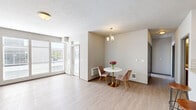 Located at 11813 E Broadway Ave in Spokane Valley, WA, this 2-bedroom, 1-bathroom unit offers a practical and well-appointed single-floor layout. The open-concept living, dining, and kitchen area serves as the heart of the home, featuring light wood-style flooring that flows throughout the main living spaces. Large sliding glass doors flood the living room with natural light and provide direct access to a private patio, offering pleasant outdoor views. A dedicated dining nook is accented by a charming chandelier, adding a touch of elegance to the space.

The kitchen is equipped with rich dark wood cabinetry, stainless steel appliances including a gas range and refrigerator, a classic white subway tile backsplash, and a granite-topped breakfast bar — ideal for casual dining or meal prep. The full bathroom features wood-style flooring, a tub/shower combination, and dark vanity cabinetry with ample storage. Both bedrooms are carpeted and offer a quiet, comfortable retreat, with multiple closets providing generous storage throughout the unit. An in-unit laundry area adds everyday convenience. The property also includes covered carport parking set amid well-maintained landscaping.