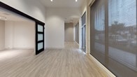 Located at 4440 Twain Ave in San Diego, Retail #101 is a single-level suite offering a contemporary and versatile layout suited for a variety of uses. The space features light-toned luxury vinyl plank flooring throughout the main areas, crisp white walls, and recessed lighting that creates a clean, bright atmosphere.

The open main area is generously proportioned, with large windows fitted with roller shades that allow for controlled natural light while maintaining privacy. A sleek sliding door with frosted glass panels adds a modern architectural detail and provides flexible room division. The connected rooms flow naturally, offering adaptable configurations.

The kitchen is well-appointed with rich, dark wood-grain cabinetry extending to the ceiling for ample storage, white quartz countertops, a textured tile backsplash, and a full suite of stainless steel appliances including a refrigerator, range, microwave, and dishwasher. Track lighting above adds both function and style.

The bathroom includes a wood-grain vanity with a white countertop, a tub-shower combination with white tile surround, and a stacked washer and dryer unit for added convenience. A separate ADA-compliant bathroom features grab bars, an open vanity, and a spacious layout. The bedroom area is carpeted and includes a sliding closet.