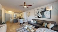 Located at 2312 Bristol Creek Dr in Morrisville, NC, this single-floor residence offers a thoughtfully designed open-concept layout that seamlessly connects the living, dining, and kitchen areas. The living room is anchored by wood-look flooring, a ceiling fan, large windows with outdoor access to a private balcony, and abundant natural light that creates a bright and welcoming atmosphere.

The kitchen is a standout feature, boasting granite countertops, a large center island with an undermount sink, two-tone cabinetry pairing white upper cabinets with dark lower cabinets, a classic subway tile backsplash, stainless steel appliances, and track lighting overhead. The adjacent dining area provides an ideal space for entertaining.

The bedrooms are carpeted and generously sized, each with ceiling fans and large windows that invite natural light. The primary bedroom includes a walk-in closet with built-in shelving for organized storage.

The bathroom is elegantly appointed with dual granite-topped vanities, dark cabinetry, a tall linen tower, wood-look flooring, and large mirrors with backlit lighting, offering both functionality and refined style. Throughout the residence, neutral tones and modern finishes create a cohesive and contemporary living environment.