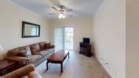 This single-floor residence offers a comfortable and functional layout thoughtfully designed for everyday living. A central hallway connects the main areas of the home, featuring a convenient pass-through window that opens to the galley-style kitchen. The kitchen is well-equipped with ample white cabinetry, generous counter space, a double sink, a stove, refrigerator, and microwave, all finished with light hardwood-style flooring that adds warmth to the space.

Adjacent to the kitchen, a dedicated dining area accommodates a full dining set and is accented by crown molding and a textured ceiling, creating an intimate space for meals. The living room is generously sized, featuring carpet flooring, crown molding, a ceiling fan with light fixture, and a sliding glass door that invites natural light and provides outdoor access.

The primary bedroom is spacious and bright, complete with a ceiling fan, plush carpeting, and direct access to an en-suite bathroom featuring a soaking tub and shower combination. A second bedroom offers comfortable proportions, a closet, and neutral finishes. A full second bathroom with tile flooring and a tub-shower combo serves the additional bedroom. Throughout, the home maintains a cohesive palette of warm neutrals, creating a welcoming and move-in ready environment.