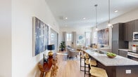 Located at 523 SW Topping Ln in Bentonville, AR, this single-floor 2-bedroom, 3-bathroom home offers a thoughtfully designed open-concept layout with contemporary finishes throughout. Light hardwood flooring flows seamlessly from the welcoming entryway—accented by high ceilings and a stylish console table—into the main living area. The kitchen is a standout feature, showcasing rich dark cabinetry, granite countertops, stainless steel appliances, a central island with bar seating, and pendant lighting that adds a modern touch. The adjacent living room is bright and airy, benefiting from multiple windows that invite abundant natural light, with access that connects comfortably to the dining and kitchen spaces. The primary bedroom is a comfortable retreat with large windows and generous closet space, while the second bedroom offers equal versatility. The three bathrooms are finished with granite vanity tops and dark cabinetry; the primary bath features a walk-in glass shower and a dual-sink vanity, while a secondary bath includes a tub-shower combination. The home's clean, neutral palette, recessed lighting, and cohesive design make it a functional and inviting residence in the heart of Bentonville.