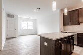 Located at 1037 Raritan Rd in Clark, NJ, this well-appointed 2-bedroom, 2-bathroom residence offers a thoughtfully designed single-floor layout with modern finishes throughout. The open-concept kitchen and living area serves as the heart of the home, anchored by a large center island with a crisp white quartz countertop and rich dark-espresso cabinetry. Pendant lighting highlights the island, while a classic subway tile backsplash and a full suite of stainless steel appliances — including a gas range, microwave, dishwasher, and refrigerator — complete the kitchen. An in-unit washer is conveniently tucked nearby. Light-toned hardwood flooring flows seamlessly through the living spaces and both bedrooms, lending a clean and cohesive aesthetic. The generously sized primary bedroom receives ample natural light through large windows with outdoor views. The second bedroom also features a wide window and a sliding-door closet with built-in rod storage. Both bathrooms are finished with large-format tile flooring and tile-surround showers or tub-shower combinations, complemented by dark wood vanities and white quartz countertops. The overall ambiance is bright, modern, and move-in ready.