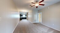 Located at 9190 E Old Spanish Trail in Tucson, Arizona, this single-story, 3-bedroom, 2-bathroom home offers a practical and comfortable layout. The open-concept living and kitchen area serves as the heart of the home, with plush carpeting in the living space and a ceiling fan providing year-round comfort. Natural light enters through a window, creating a bright and welcoming atmosphere.

The U-shaped kitchen is well-appointed with dark espresso cabinetry, white countertops, tile flooring, and black appliances including an electric range, microwave, and refrigerator. A window above the sink allows for additional natural light.

The primary bedroom features soft carpet, a ceiling fan, and a spacious walk-in closet with built-in shelving. The en-suite bathroom includes a dark-toned vanity, tile flooring, a large mirror, and a glass-enclosed walk-in shower with open shelving. The second bathroom offers a full tub-shower combo with white tile surround and a matching vanity.

The two additional bedrooms are carpeted and well-sized, each with ceiling fans and closets. A dedicated laundry room houses side-by-side washer and dryer units with overhead shelving for added storage. The home's neutral color palette and functional design make it a versatile and move-in-ready living space.