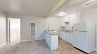 Located at 2909 Marconi Ave in Arden-Arcade, California, this one-bedroom, one-bathroom unit offers a thoughtfully arranged single-floor layout that maximizes every inch of its compact footprint. The open-concept kitchen and living area serves as the heart of the unit, featuring white cabinetry with granite-look countertops, a gas range, a full-size refrigerator, and a functional peninsula with built-in open shelving below — ideal for additional storage or display. Light wood-look flooring grounds the kitchen area, transitioning seamlessly to plush carpet in the living space. Exposed ceiling beams and a flush-mount light fixture add subtle architectural character, while a wall-mounted heating unit ensures year-round comfort. The bedroom is a well-proportioned retreat with soft carpeting, a ceiling fan with integrated lighting, a natural light-filled window with blinds, and direct access to a dedicated closet. The bathroom is clean and efficiently designed, featuring wood-look tile flooring, a pedestal-style sink, a mirror cabinet, and a window that brings in natural light. The unit's neutral color palette throughout creates a bright, cohesive, and move-in ready atmosphere.