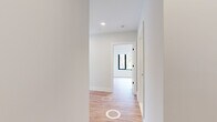 Located at 500 Parq Ln in Parsippany, NJ, this thoughtfully designed 2-bedroom, 2-bathroom residence offers a clean, modern aesthetic across a single floor. Light hardwood flooring runs throughout the main living areas, complementing the bright, neutral color palette that defines the space.

The open-plan kitchen and living area serves as the heart of the home. The kitchen features sleek, high-gloss white cabinetry paired with warm wood-toned lower cabinets and island, white quartz countertops, stainless steel appliances, and a contemporary linear pendant light — a well-appointed space suited for both everyday cooking and entertaining.

The living room is a standout feature, boasting expansive floor-to-ceiling corner windows that flood the space with natural light and provide sweeping views of the surrounding landscaped grounds and community.

The generously sized primary bedroom includes a large window with outdoor views and a wall-mounted split HVAC unit, offering comfort year-round. The second bedroom features the same light flooring and crisp white walls.

Both bathrooms are finished with large-format tile flooring and wood-toned vanity cabinetry with white countertops. The primary bath includes a glass-enclosed walk-in shower with full tile surround, while the second bathroom offers a clean, functional layout with a shower-tub combination.