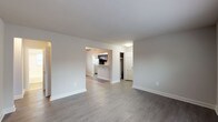 This single-floor residence offers a thoughtfully designed layout with a clean, neutral aesthetic throughout. The open living area features durable wood-style flooring, crisp white baseboards, and soft gray walls that create a bright and welcoming atmosphere. A ceiling fan adds both function and character to the dining area, which flows seamlessly into the kitchen via a convenient breakfast bar — ideal for casual dining or entertaining.

The kitchen is well-equipped and efficiently laid out, showcasing rich dark espresso cabinetry, granite-style countertops, a stainless steel refrigerator, gas range, and a window that invites natural light into the space. Ample cabinet storage lines the walls, providing generous room for organization.

The two bedrooms are comfortably sized, each featuring plush carpeting, ceiling fans, radiator heating units, and windows that allow natural light to filter in. The rooms offer a cozy and restful environment well-suited for relaxation.

The full bathroom is finished with classic white subway tile surrounding the tub-shower combination, complemented by a dark-toned vanity and wood-style flooring. A window provides ventilation and natural light.

Throughout the unit, a consistent design palette of neutral tones, modern fixtures, and functional finishes creates a cohesive and move-in-ready living environment.