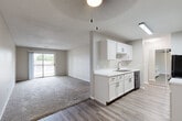 Located at 1265 11th St in West Des Moines, Iowa, this 2-bedroom, 1-bathroom single-story home offers a clean, modern aesthetic throughout. The open-concept layout seamlessly connects the kitchen, dining, and living areas, creating a bright and functional shared space. The kitchen is outfitted with white shaker-style cabinetry featuring black hardware, white countertops, a stainless steel sink, and a dishwasher, all set atop durable wood-look vinyl plank flooring. The living area transitions to soft, neutral-toned carpet and is anchored by a sliding glass door that invites natural light and provides outdoor access. Both bedrooms are carpeted and include ceiling fans with light fixtures and windows that bring in natural light. The spacious primary bedroom features a generous walk-in closet with wrap-around shelving, while the home boasts a total of five closets, offering abundant storage throughout. The bathroom is well-appointed with a gray vanity, white countertop, and a full tub-shower combination set on wood-look vinyl flooring. A connecting hallway ties the living spaces together efficiently. Neutral wall tones and textured ceilings lend the home a cohesive, move-in-ready feel.