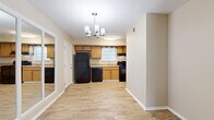 Located at 2355 W Michigan Ave in Pensacola, FL, this single-story, 2-bedroom, 2-bathroom home offers a practical and well-organized layout. Wood-look flooring flows consistently throughout the living areas, bedrooms, hallway, and kitchen, lending a cohesive, clean aesthetic to the entire space.

The living room is bright and open, featuring a sliding glass door that fills the room with natural light and provides views of the surrounding greenery outside. Adjacent to the living area, the dining room connects seamlessly to the kitchen, which is equipped with warm honey-toned cabinetry, black appliances including a refrigerator, dishwasher, and range, a single-basin sink beneath a window, and a stylish chandelier overhead.

The primary bedroom is generously sized, featuring two windows that invite ample natural light and a ceiling fan with light fixture. A mirrored sliding-door closet adds both storage and visual depth to the room. The second bedroom also includes a ceiling fan and maintains the same neutral, warm tones found throughout the home.

Both bathrooms are finished with white cabinetry, granite-style countertops, and a tub-shower combination. The neutral color palette and consistent flooring throughout create a calm and inviting atmosphere suited for comfortable everyday living.