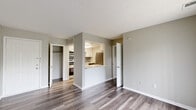 Located at 7266 Lockwood Ln in Indianapolis, IN, this one-bedroom, one-bathroom unit offers a thoughtfully organized layout across a single floor. The living area features neutral gray walls, clean white baseboards, and durable luxury vinyl plank flooring in a cool gray wood tone that flows consistently throughout the space. A textured ceiling adds subtle character overhead, while vertical blinds and a window in the bedroom allow natural light to filter in.

The kitchen is efficiently designed with white shaker-style cabinetry, bright white countertops, and a gray subway tile backsplash that adds a modern touch. A stainless steel single-basin sink with a flexible-head faucet, a dishwasher, and additional appliances round out the kitchen's functionality. A pass-through opening connects the kitchen to the main living area, enhancing the sense of openness.

The bedroom is a comfortable, well-proportioned room featuring a sliding closet with a built-in hanging rod for organized storage. Adjacent to the bedroom is a dedicated closet area with open shelving, alongside a stacked washer and dryer unit—a convenient in-unit laundry feature. The bathroom is clean and simply appointed. Overall, the space presents a fresh, move-in-ready aesthetic with practical, modern updates throughout.