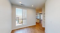 Located in Denver's Stapleton/Central Park neighborhood, this single-floor residence offers a clean, contemporary design throughout. The open-concept living and kitchen area serves as the heart of the home, anchored by warm hardwood-style flooring and recessed lighting. The kitchen is well-equipped with crisp white cabinetry, dark countertops, stainless steel appliances, a subway tile backsplash, and a central island with pendant lighting overhead — ideal for both cooking and casual dining. A ceiling fan adds comfort to the adjoining living space, which opens to a bright area with a large window overlooking the neighborhood. Built-in shelving provides additional storage and display space near the living area. The bedrooms are carpeted for comfort and filled with natural light courtesy of generous windows with views of the surrounding streetscape and greenery. The primary bathroom features tile flooring, a single-sink vanity with dark countertop, and a glass-enclosed walk-in shower with subway tile surround. A second bathroom offers a full tub-shower combination, also finished with subway tile. Throughout the home, a neutral color palette and modern finishes create a bright, cohesive atmosphere suited to a variety of lifestyles.