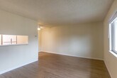 Located at 3094 Lake Dr in Marina, California, this single-floor, one-bedroom, one-bathroom residence offers a practical and comfortable layout. Light wood-style flooring runs throughout, lending a clean, cohesive look to the interior.

The living room is an open, airy space featuring a textured ceiling and a ceiling fan. A pass-through window connects the living area to the kitchen, providing an open feel between the two spaces. Sliding glass doors lead from the living room to a private balcony with views of the surrounding neighborhood and mature trees.

The kitchen is efficiently designed with warm wood cabinetry, white countertops, and full appliance suite including a gas range, microwave, dishwasher, and refrigerator. Ample cabinet storage makes the most of the galley-style layout.

The bedroom is a comfortable, well-proportioned room with a mirrored sliding-door closet offering generous storage. Light wood flooring continues here, and the neutral wall tones maintain a calm atmosphere throughout.

The bathroom includes a full tub-shower combination, a vanity with a white countertop and warm wood cabinetry, and a small window for ventilation. Additional storage is provided by two closets and a utility room, enhancing the home's functional appeal.
