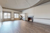 Located at 870 Westminster St in Providence, Rhode Island, this remarkable 2-bedroom, 2-bathroom residence is a masterclass in historic character blended with modern updates. The centerpiece of the home is the expansive living room, crowned by a dramatic domed ceiling with intricate ornate molding that curves gracefully around the room's perimeter — a rare architectural feature that immediately commands attention. Rich hardwood-style flooring flows throughout, grounding the grandeur of the space with warmth and continuity. An elegant marble-mantled fireplace with brick surround serves as a striking focal point, adding timeless charm to the living area. Tall windows dressed with blinds invite abundant natural light while offering views of the surrounding streetscape. The kitchen is neatly integrated into the open-plan layout, featuring warm wood cabinetry, a classic subway tile backsplash, stainless steel appliances, and generous counter space. Both bedrooms are comfortably proportioned, with the primary bedroom offering a ceiling fan, a large window, and a closet. The two bathrooms are clean and functional, with one featuring a glass-enclosed walk-in shower and a wood-vanity. A dedicated closet rounds out the layout, providing practical storage in this historically distinguished Providence residence.