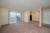 Located at 3950 Waring Road in Oceanside, California, this two-bedroom, one-bathroom residence offers a well-organized single-floor layout designed for comfortable everyday living. The interior features warm, neutral-toned walls and plush carpeting throughout the living and bedroom areas, creating a cohesive and inviting atmosphere.

The kitchen is efficiently laid out in a U-shaped configuration, featuring white cabinetry, dark countertops, tile flooring, and black appliances including a refrigerator and dishwasher. A window above the sink provides natural light, while a ceiling-mounted light fixture ensures bright illumination. The kitchen connects conveniently to the dining area.

Both bedrooms are carpeted and finished with the same warm neutral palette. Each room is equipped with vertical blinds over windows that allow for adjustable natural light. The primary bedroom offers a generous footprint with closet access, while the second bedroom provides a comfortable, well-proportioned space. Three closets throughout the unit offer ample storage options.

The bathroom includes a full soaking tub with a tiled surround in light beige tones and a frosted window above for privacy and ventilation. The unit also features a private balcony, adding a functional outdoor extension to the living space. A wall-mounted heating unit is present in one of the bedrooms, ensuring year-round comfort.
