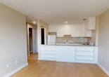 This 42 square meter apartment offers a thoughtful design that maximizes space and functionality. The single-floor layout comprises a hallway, one bedroom, one bathroom, and a kitchen, creating an ideal living space for individuals or couples. The primary bedroom, measuring 12 square meters, provides ample room for rest and relaxation.

The kitchen is a standout feature, boasting white cabinetry that extends to the ceiling, maximizing storage. Marble-look countertops add a touch of elegance, while modern appliances, including a white refrigerator and stove, ensure convenience. A breakfast bar separates the kitchen from the living area, offering additional counter space and casual dining options.

The bathroom is fully tiled in a clean, contemporary style with horizontal white tiles. It features a full-sized bathtub, pedestal sink, and a mirror, creating a bright and functional space. Throughout the apartment, hardwood floors add warmth and are easy to maintain.

Large windows in the bedroom and living areas flood the space with natural light, creating an open and airy atmosphere. The neutral color palette of white and beige tones provides a blank canvas for personalization. Recessed lighting in the kitchen and bedroom offers additional illumination options.

Located at 46-1196 Shillington, this apartment combines modern amenities with efficient design, making it an attractive option for urban living.