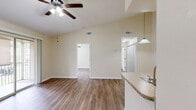 Located at 2351 Pine Brook Dr in Kissimmee, FL, this single-floor, one-bedroom, one-bathroom unit offers a functional and well-appointed layout. The open living and dining area is anchored by warm wood-look laminate flooring that extends throughout the space, complemented by neutral beige walls and clean white trim. A ceiling fan with a built-in light fixture adds both comfort and style to the living area, which also features a sliding glass door opening to a private balcony with outdoor views. The galley-style kitchen is efficiently designed with warm-toned wood cabinetry, granite-style countertops, a stainless steel sink, and white appliances, including a refrigerator, range, and dishwasher. A peninsula counter connects the kitchen to the living area, ideal for casual dining. The bedroom is a comfortable, well-lit space featuring a large window with outdoor views, a ceiling fan, and continued wood-look flooring. The bathroom includes a warm wood vanity with granite-style countertops and a framed mirror. A hallway with a closet provides additional storage. The unit's cohesive finishes and practical floor plan make it a well-organized and inviting living space.